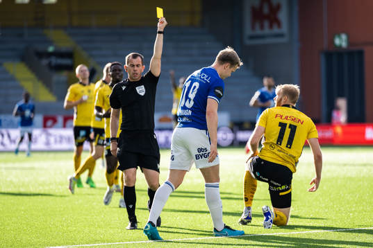 Referee Peter Bankes gives Eirik Haugan of Molde a yellow