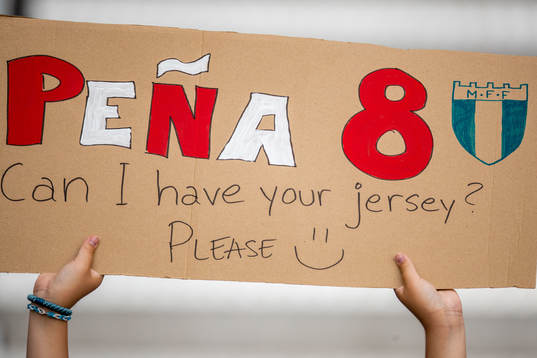 A fan with a sign askin Sergio Pena for his jersey