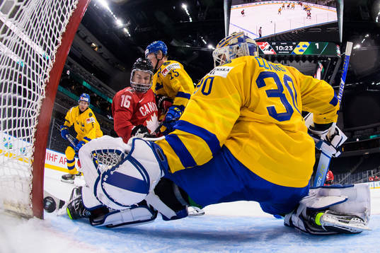 Connor Bedard of Canada challenges Åke Stakkestad and