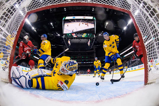 Connor Bedard and Joshua Roy of Canada challenge Åke