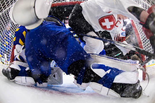Simon Knak of Switzerland crashes into the goal behind