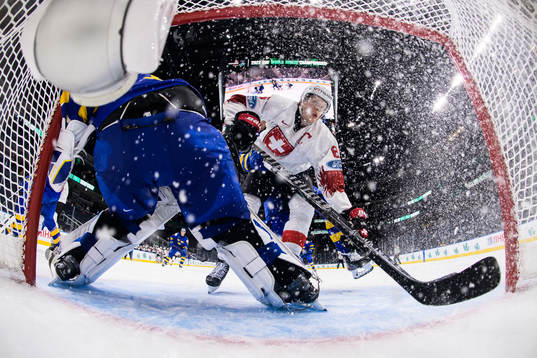 Simon Knak of Switzerland crashes into the goal behind