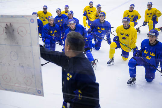 Players listen to head coach Tomas Montén of Sweden at a