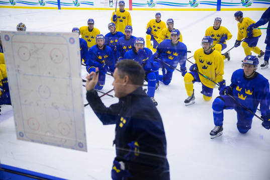 Players listen to head coach Tomas Montén of Sweden at a