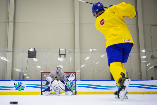 Goaltender Jesper Wallstedt and Oskar Magnusson of Sweden