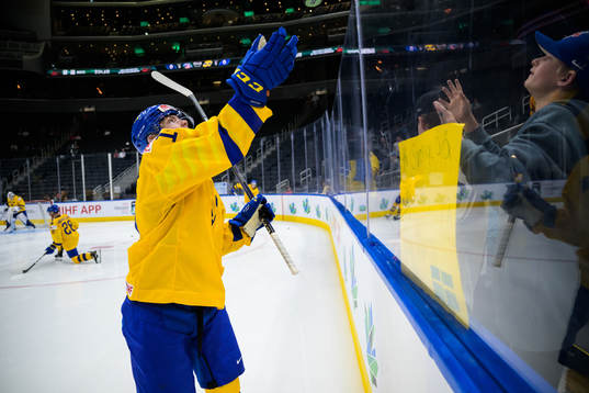 Victor Stjernborg of Sweden tosses a puck to a fan at