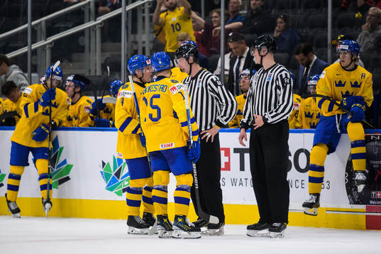 Emil Andrae and Åke Stakkestad of Sweden talk to a linesman