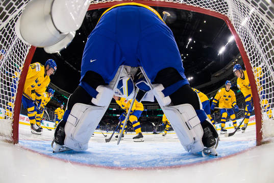 Players of Sweden gather around goaltender Jesper Wallstedt