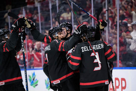 Ridly Greig of Canada celebrates with teammates