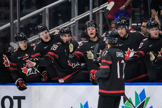 Ridly Greig of Canada celebrates with teammates