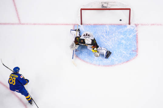 Oskar Magnusson of Sweden scores 3-1 behind goaltender