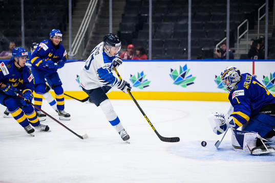 Kasper Puutio of Finland scores 0-1 behind goaltender
