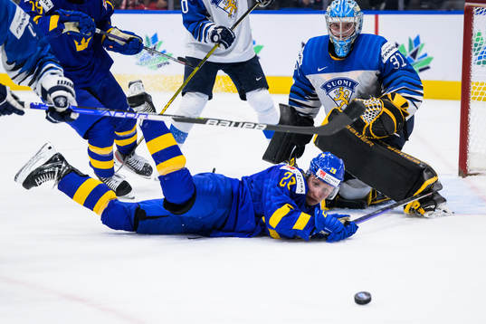 Oskar Magnusson of Sweden trips in front of goaltender Juha
