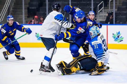 Daniel Torgersson of Sweden in front of goaltender Juha