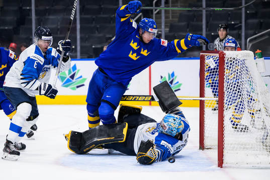 Daniel Torgersson of Sweden trips over goaltender Juha