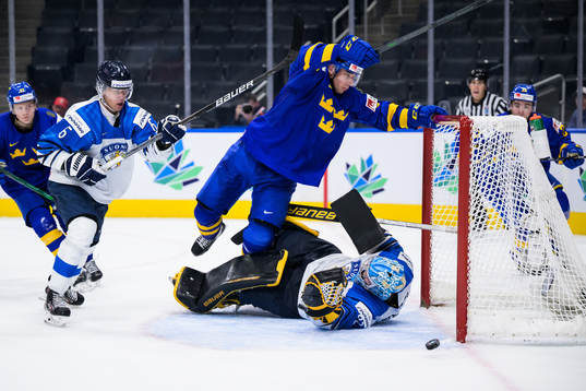 Daniel Torgersson of Sweden trips over goaltender Juha