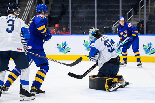Goaltender Juha Jatkola of Finland gets hit by a puck