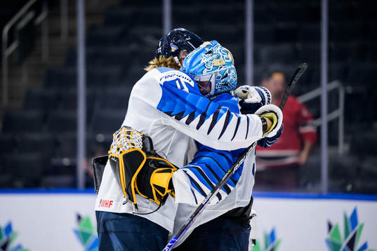Joni Jurmo and goaltender Juha Jatkola of Finland embrace