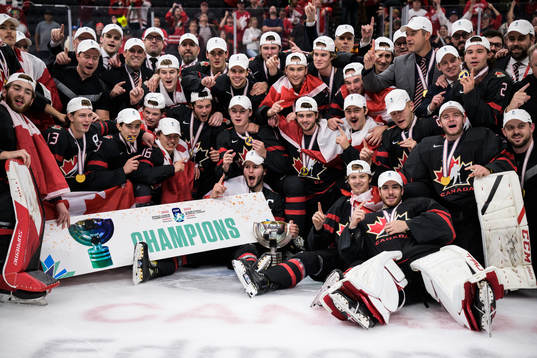 Players and coaching staff of Canada celebrate