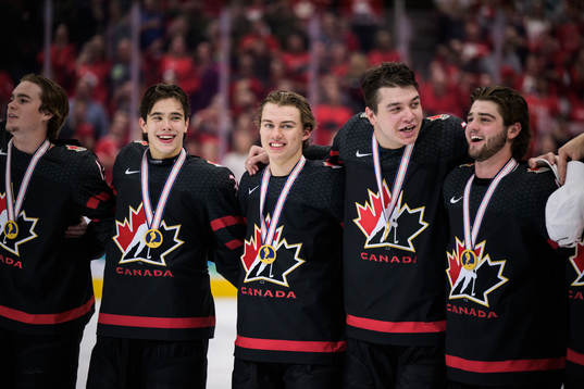 Connor Bedard of Canada in center with his gold medal