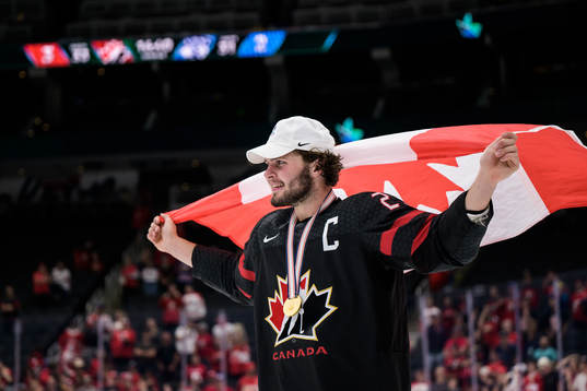 Mason McTavish of Canada celebrates with a Canadian flag