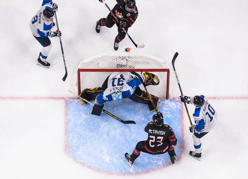 Kent Johnson and Mason McTavish of Canada try to score