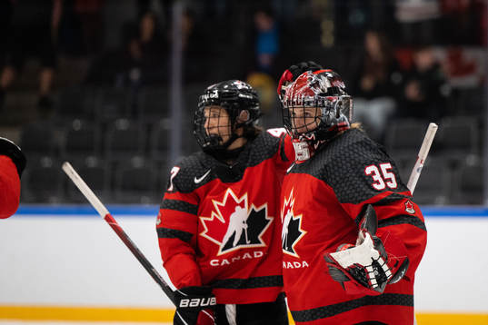 Ella Shelton and goaltender Ann-Renee Desbiens celebrate