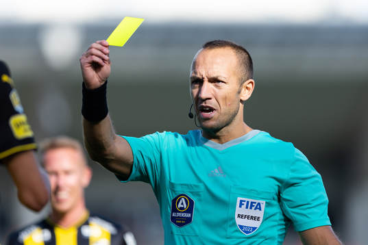 Domare Kaspar Sjöberg delar ut ett gult kort till Häckens