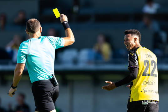 Domare Kaspar Sjöberg delar ute ett gult kort till Tobias