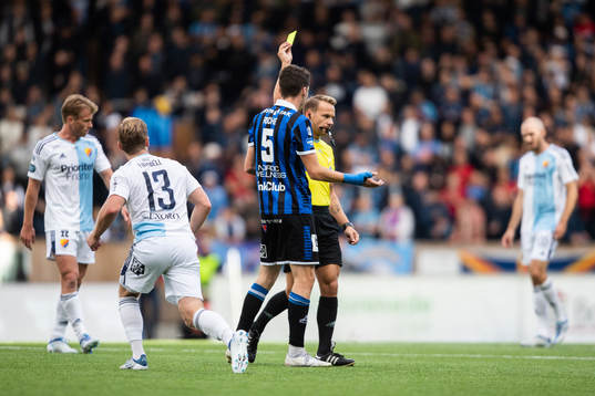 Domare Kristoffer Karlsson delar ut ett gult kort till
