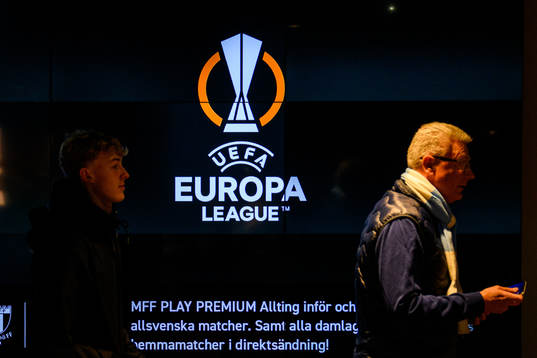Visitors next to logos for the UEFA Europa League