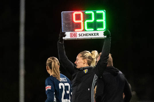 Fjärdedomare Isabelle Svensson visar upp tavla med siffror
