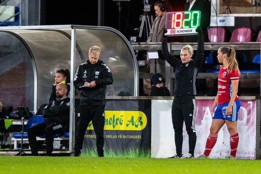 Fjärdedomare Isabelle Svensson visar upp tavla med siffror