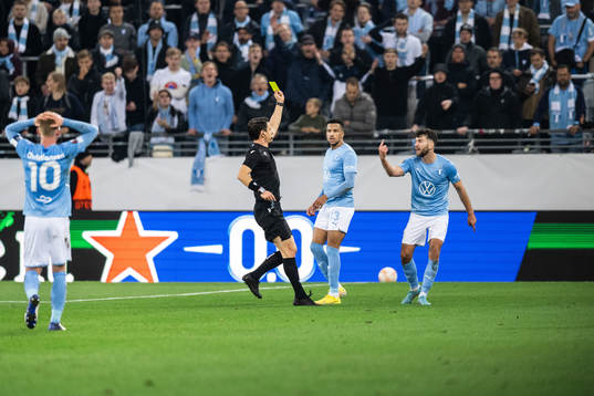 Erdal Rakip of Malmö FF receives a yellow card from