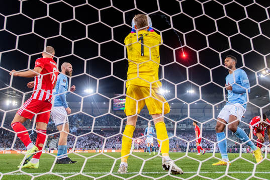 A flare is thrown onto the pitch as goalkeeper Frederik