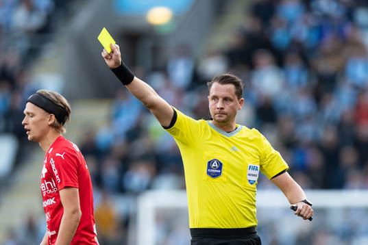 Domare Andreas Ekberg delar ut gult kort till Värnamos