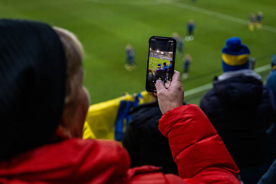 A woman is filming with her mobile phone