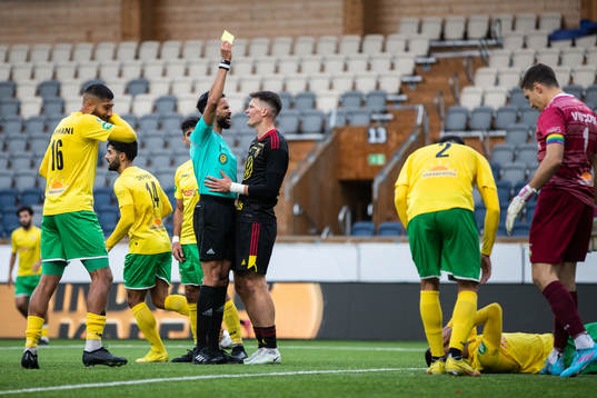 Domare Farouk Nehdi delar ut ett gult kort till Östersunds