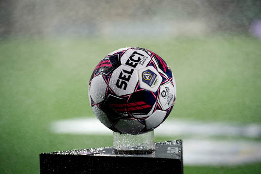 En boll blir blöt av bevattning innan fotbollsmatchen i