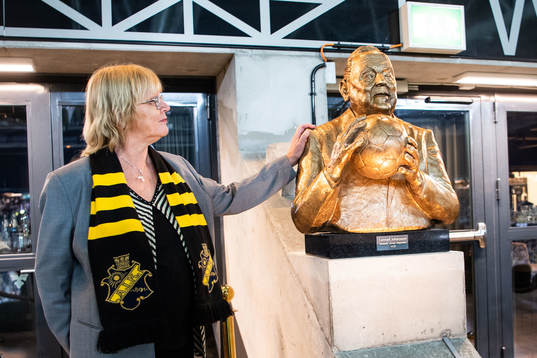 Eva Jansson med en minnesskulptur av Lennart Johansson
