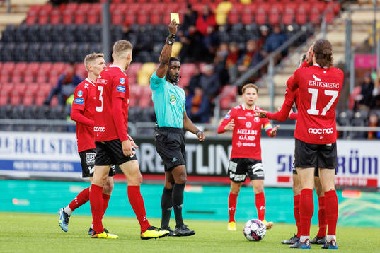 Domare Fredrik Oppong visar ett gult kort