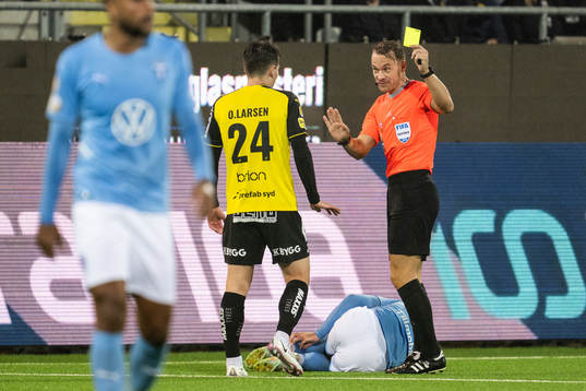 Domare Kristoffer Karlsson delar ut ett gult kort till