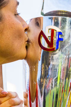 Ingrid Ryland of Brann kisses the trophy