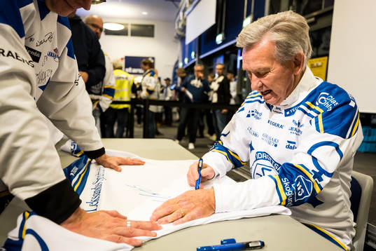 Mats Åhlberg signerar tröjor innan ishockeymatchen i SHL