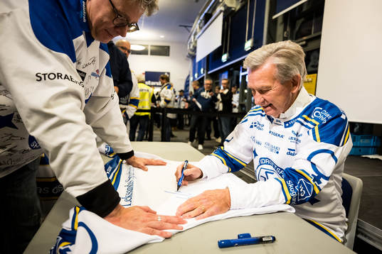 Mats Åhlberg signerar tröjor innan ishockeymatchen i SHL