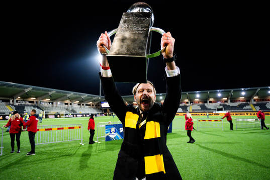Häckens Häckens klubbchef Marcus Jodin jublar med pokalen
