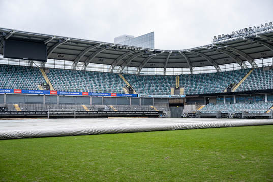 Ett skydd rullas ut över gräset på fotbollsplanen på