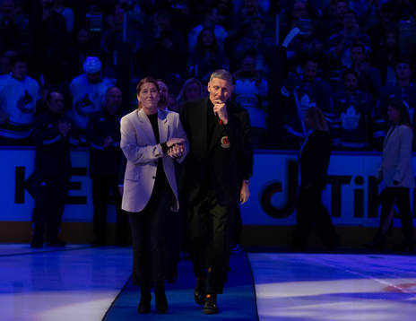 Börje Salming and his wife Pia Salming walk to centre ice