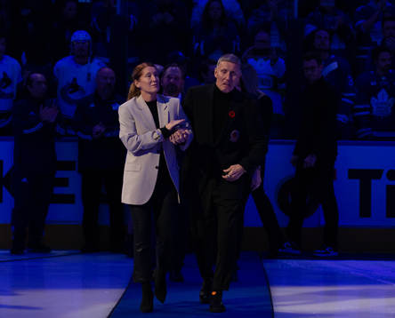 Börje Salming and his wife Pia Salming walk to centre ice