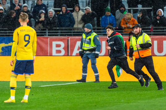 Security personel chase a pitch invader